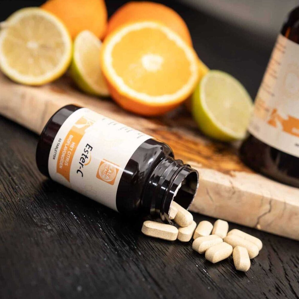 Ester-C vitamine C tabletten rollen uit fles met verse citrusvruchten op houten oppervlak