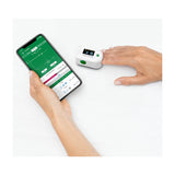 Close-up van Medisana saturatiemeter aan vinger met app grafiek op scherm