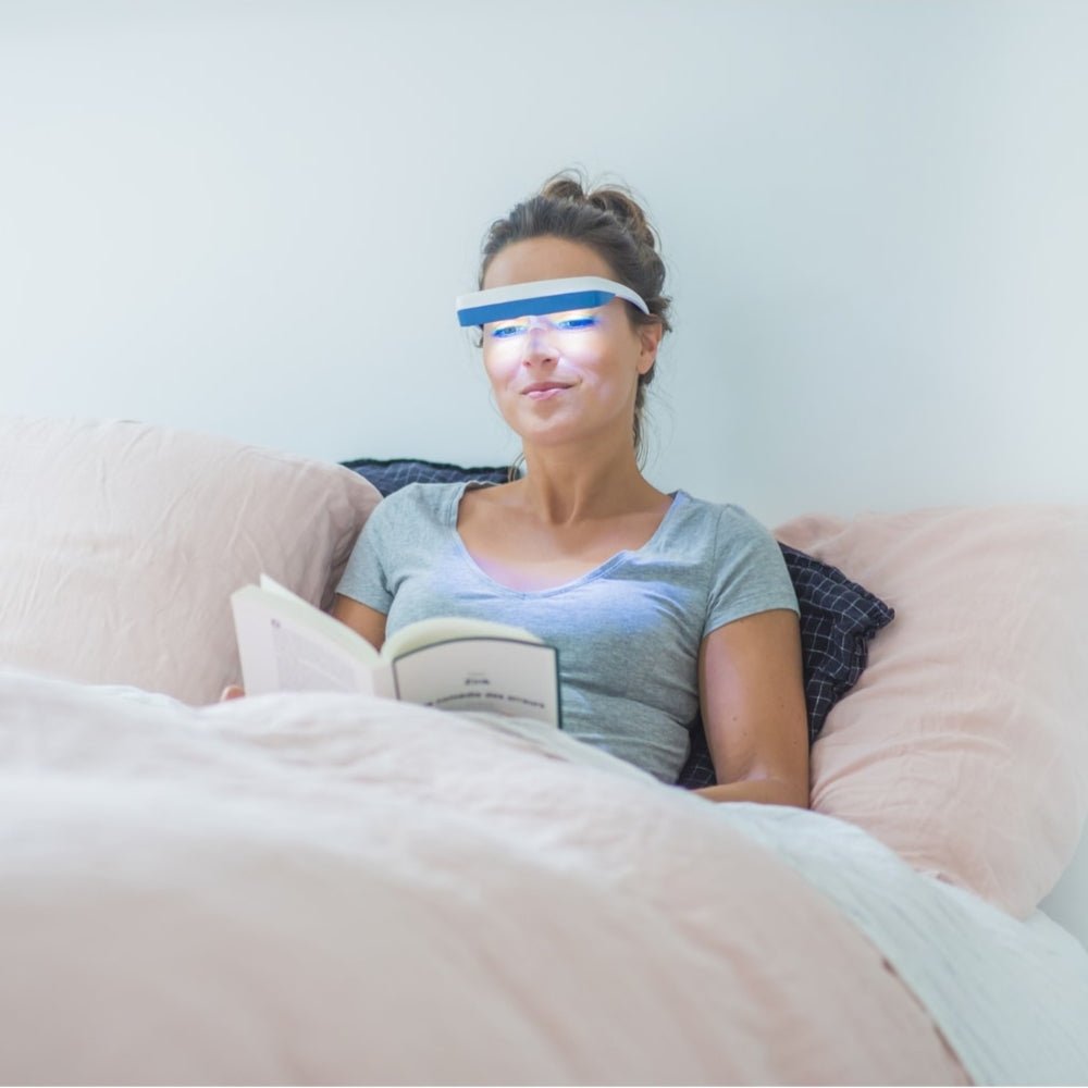 Vrouw leest boek terwijl ze Luminette 3 lichttherapiebril draagt voor winterdip