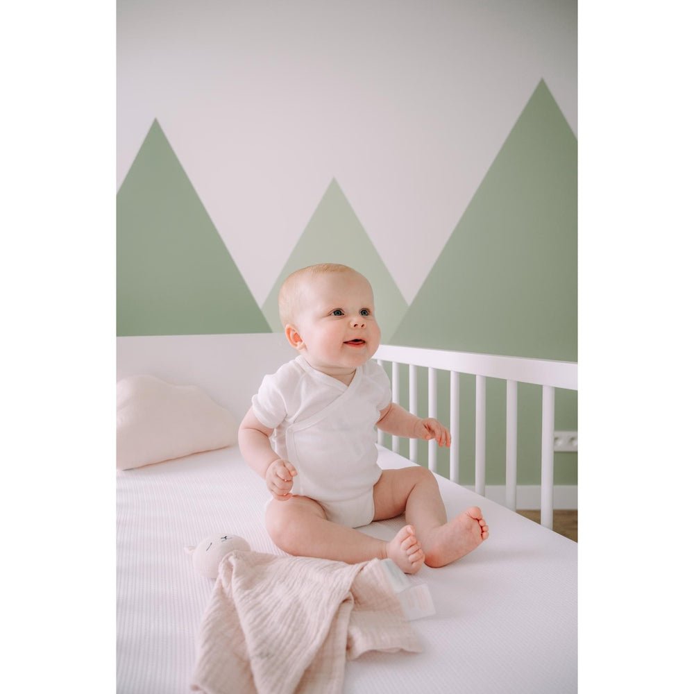 Baby in wieg met wit AirgoSafe hoeslaken voor optimale luchtcirculatie