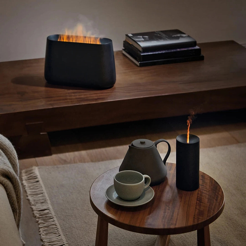 Twee zwarte Stadler Form diffusers met oranje gloed effect interieur
