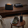 Twee zwarte Stadler Form diffusers met oranje gloed effect interieur