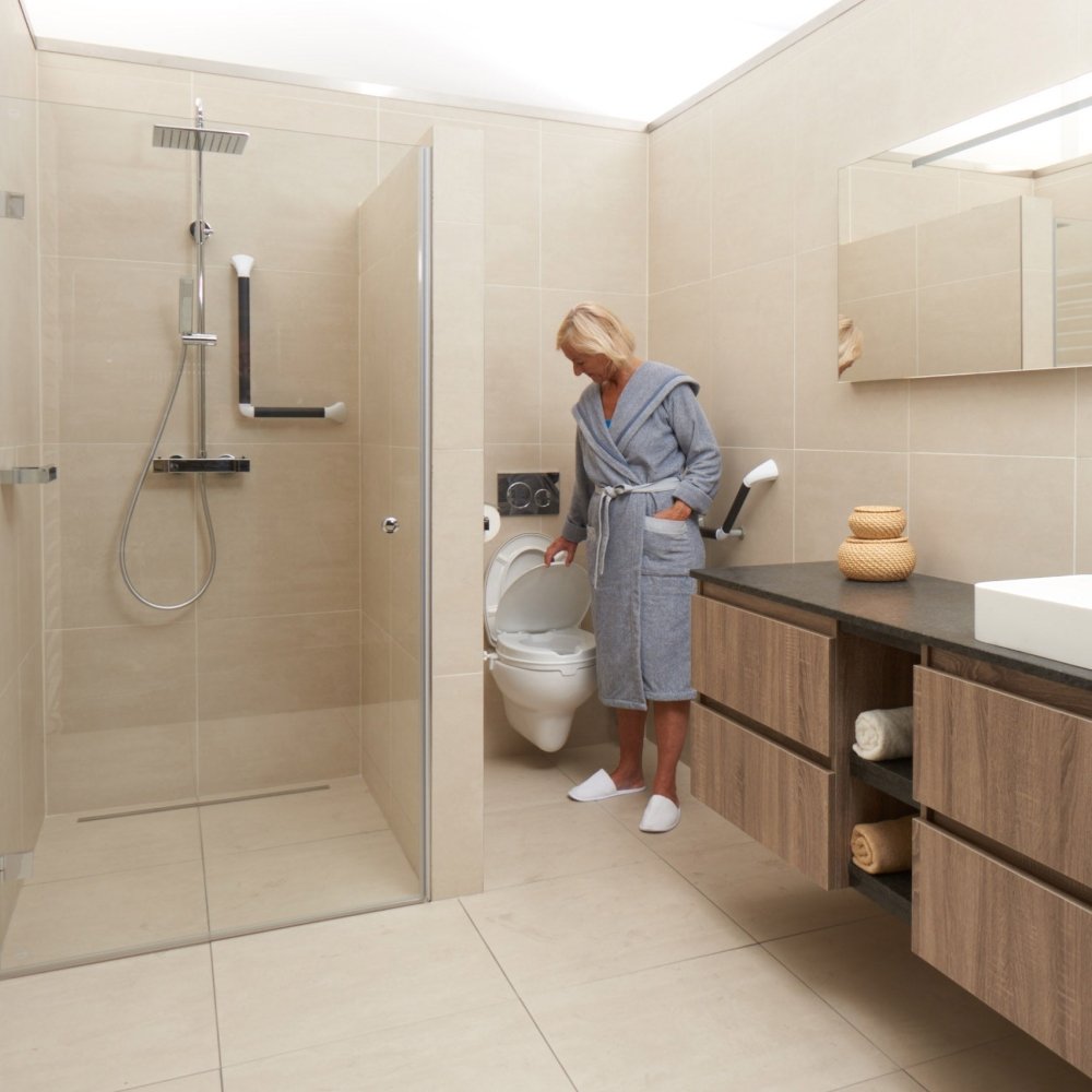 Vrouw gebruikt witte toiletverhoger met klep in moderne badkamer