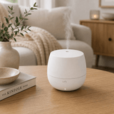Stadler Form Mia aroma diffuser in het wit, met stoompluim op houten tafel
