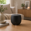 Stadler Form Mia aroma diffuser zwart met mat oppervlak en nevel op houten tafel