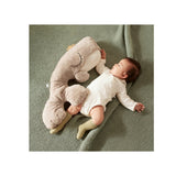 Baby slaapt naast grijze Topbright slaaptrainer walvis op groene deken
