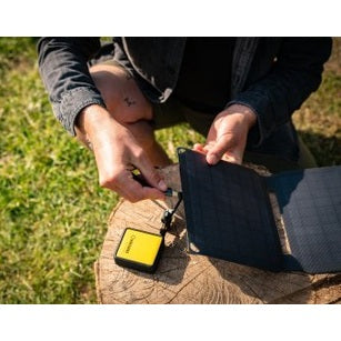 Zonnepaneel power bank set in gebruik voor outdoor opladen met kabel