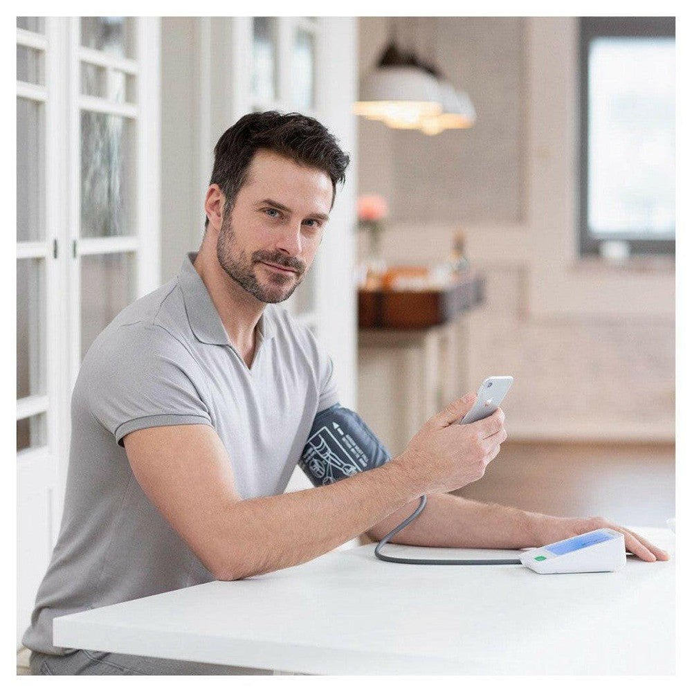Man meet bloeddruk thuis met Medisana app verbinding via smartphone