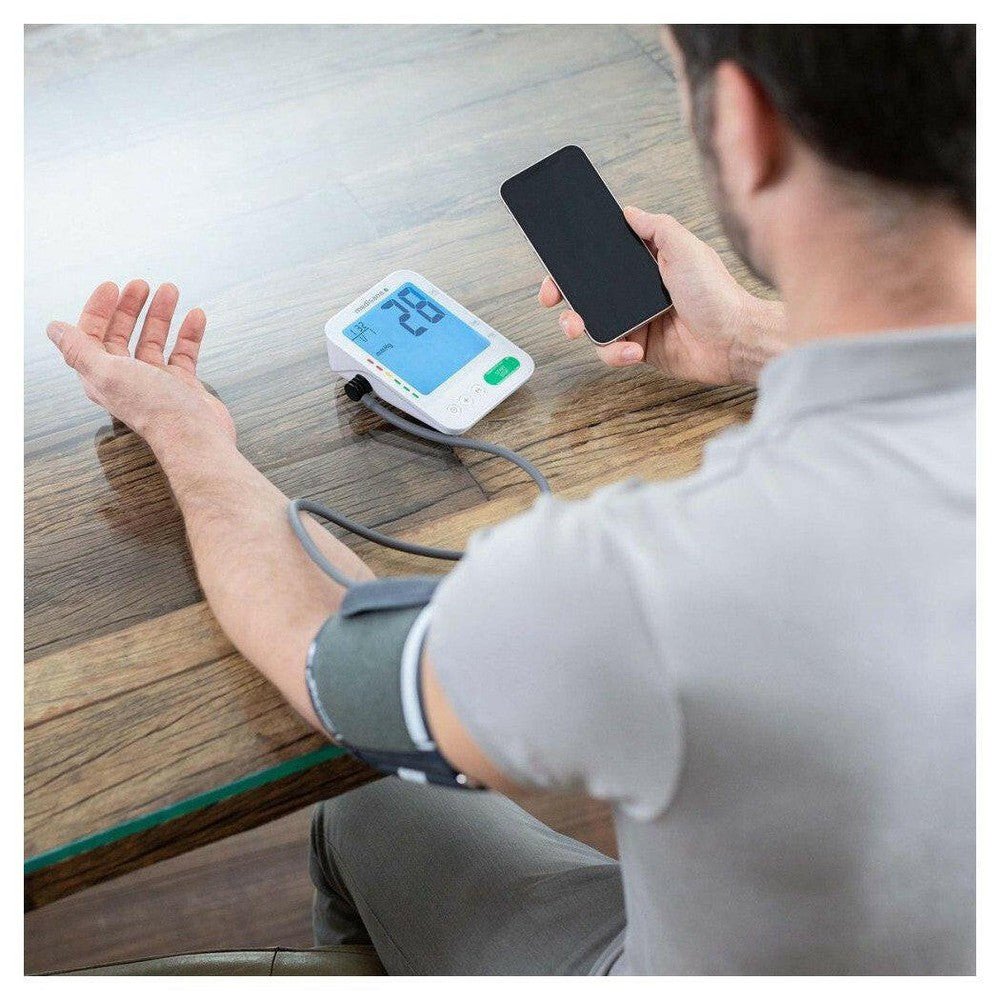 Gebruiker controleert bloeddrukmeting op smartphone met Medisana connect app