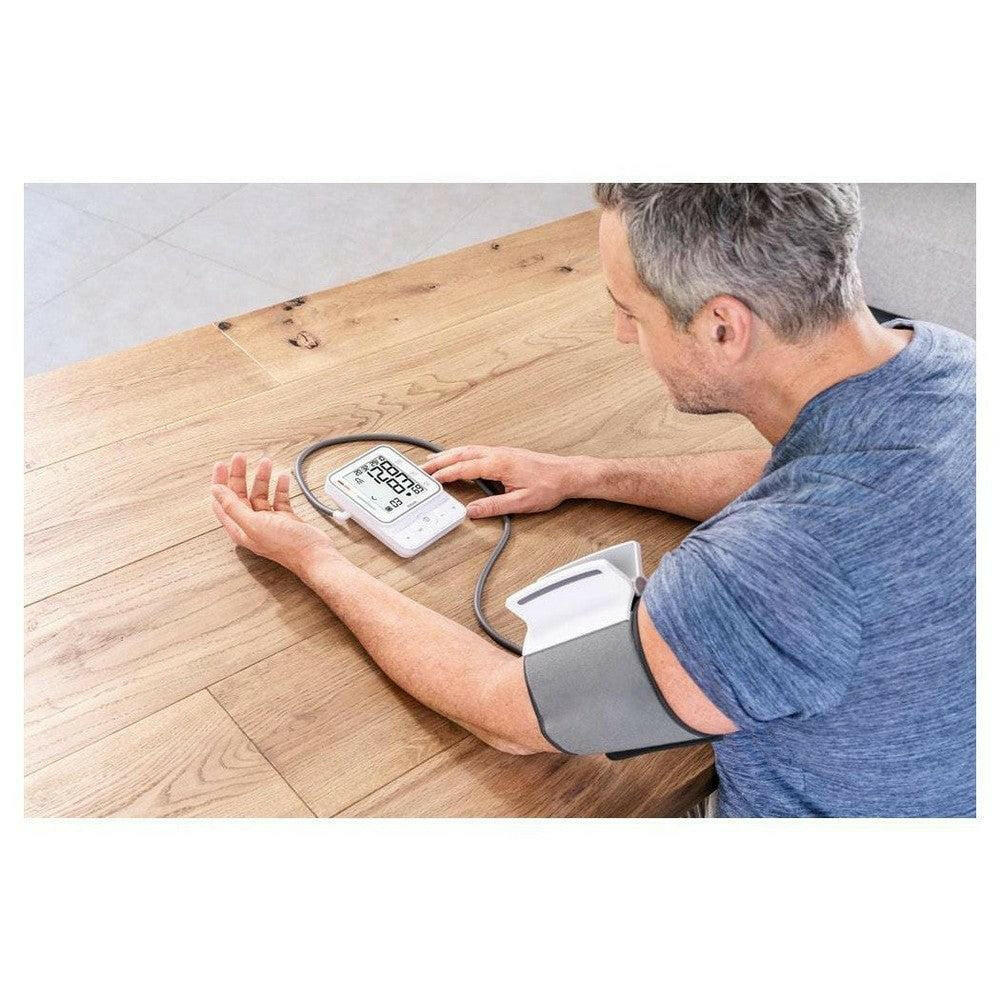 Beurer BM51 bloeddrukmeter met grijze voorgevormde manchet op houten tafel