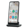 Doro 8100 senioren smartphone zwart met Android-homescherm op oplaadstandaard