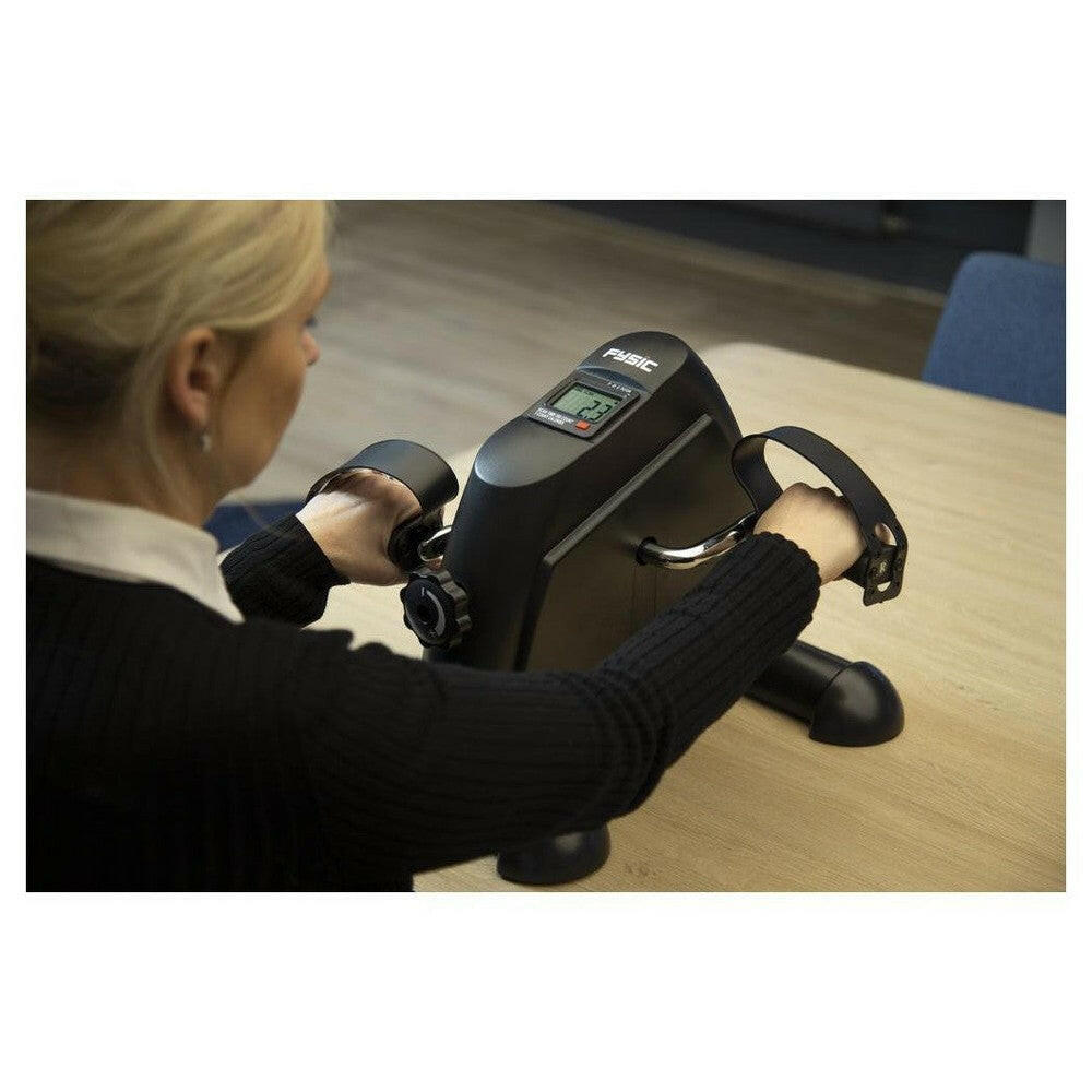Persoon gebruikt Fysic fietstrainer met digitale display en handgrepen