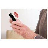 Oudere persoon houdt zwarte Fysic draadloze alarmknop vast met hand
