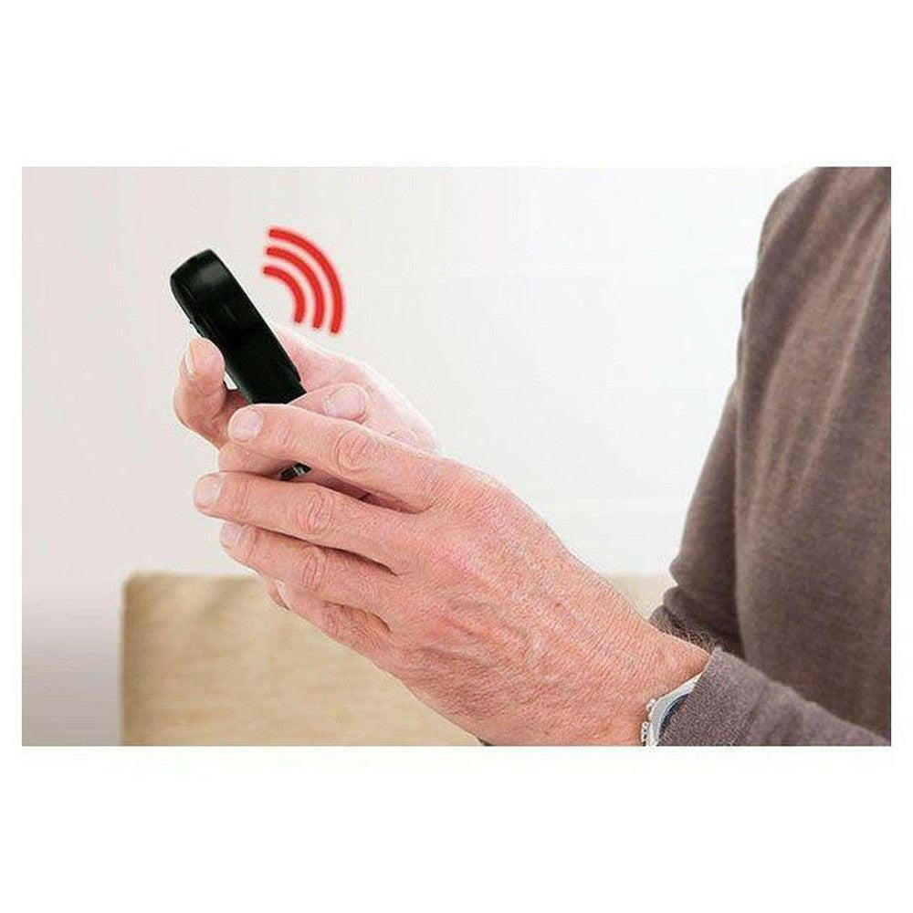 Oudere persoon houdt zwarte Fysic draadloze alarmknop vast met hand