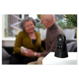 Fysic FXA-100 alarmknop in standaard met onscherpe achtergrond van senioren