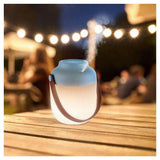 Lanaform Summer Night lamp in gebruik buiten met nevel en warme gloed op terras