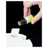 Hand vult Lanaform wake-up light met essentiele olie uit bruin flesje