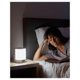 Lanaform wake-up light als helder wit nachtlampje naast lezend persoon