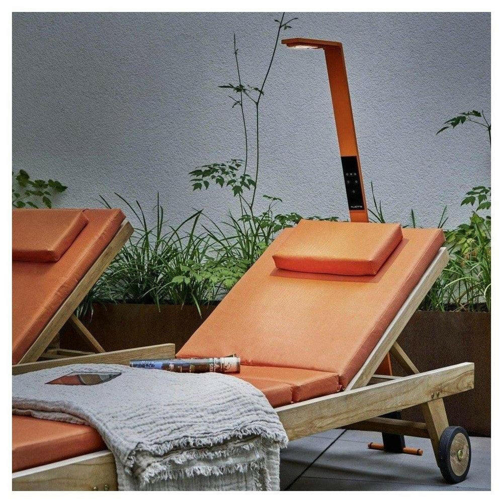Oranje LED-lamp naast ligstoelen in tuin voor ontspanning