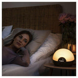 Lumie Bodyclock Glow 150 warme gloed op nachtkastje bij ontspannen gebruiker