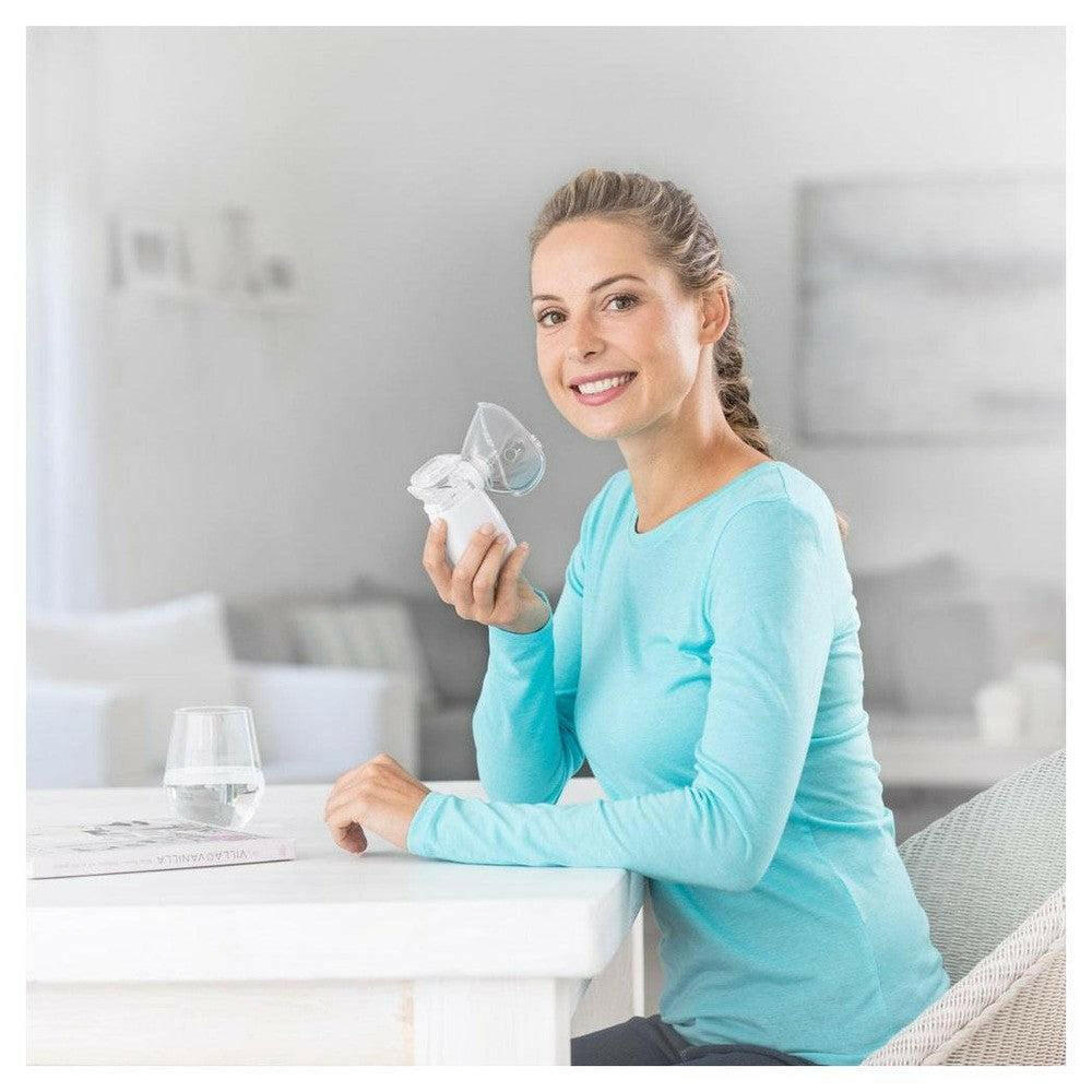Vrouw houdt compacte Medisana IN 525 inhalator vast in hand