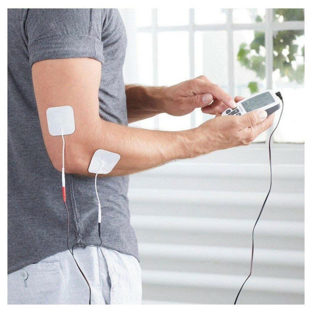 Man gebruikt Medisana TT 200 pijnbestrijding apparaat op arm met elektroden