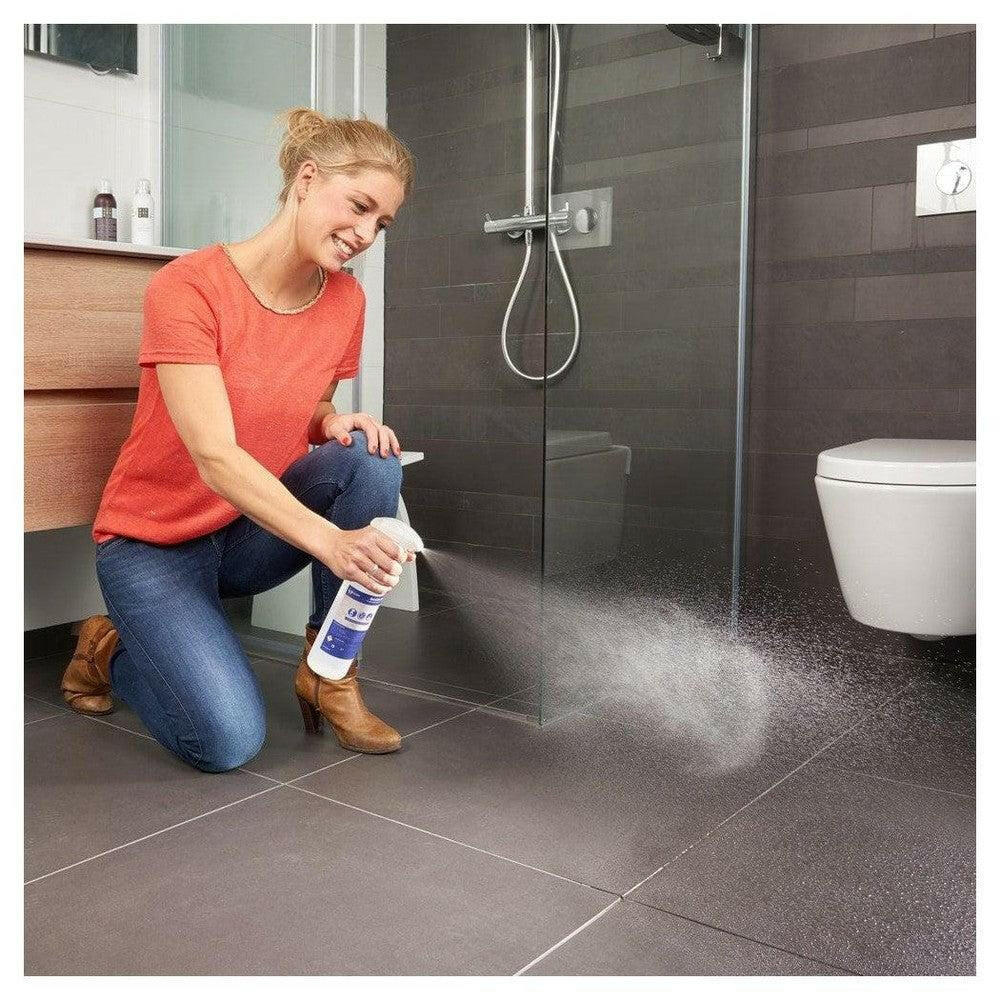 Aanbrengen SecuCare antislip spray op grote donkergrijze badkamertegels
