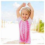 Meisje draagt roze witte Snapper Rock UV-zwemkleding op strand