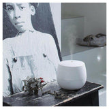 Witte aroma diffuser in gebruik met zichtbare nevel op houten tafel
