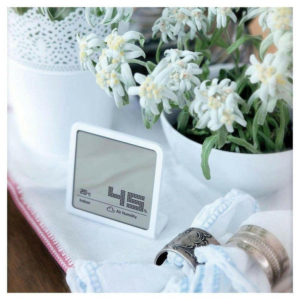 Witte Stadler Form Selina hygrometer in woonkamer op tafel met planten