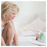 Zazu slaaptrainer roze naast kind met groene opstaand-lamp