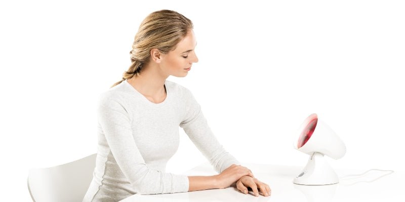 dame die een infrroodlamp gebruikt - blog "hoe werkt infraroodlichthterapie"shopvoorgezondheid