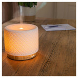 Lanaform Moya aroma diffuser op tafel met zichtbare nevel en warm licht