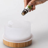 Etherische olie gieten in Lanaform Moya aroma diffuser met keramiek en bamboe