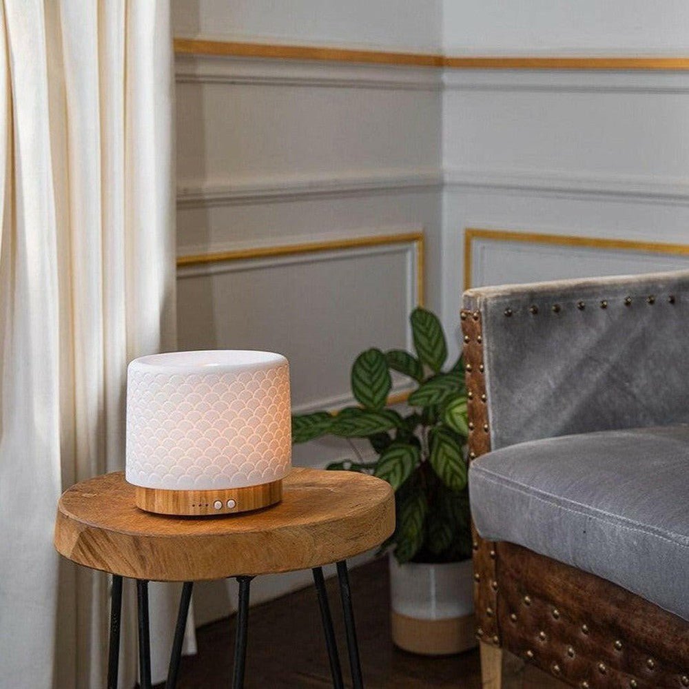 Lanaform Moya aroma diffuser wit met schubbenpatroon en bamboe voetstuk in woonkamer