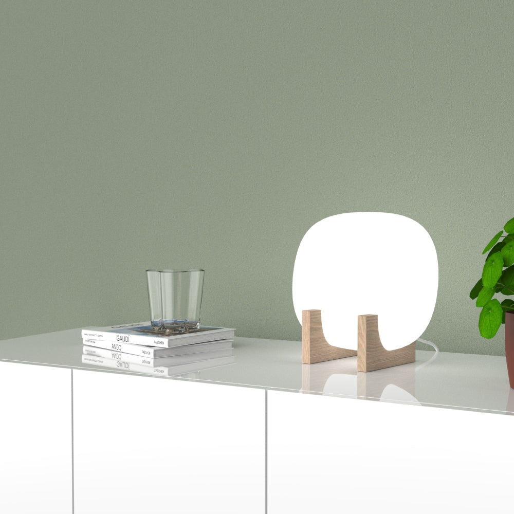 Innolux Lempi design tafellamp in woonkamer setting met boeken en plant