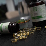 Kala Health vegan omega-3 capsules uit algenolie met EPA en DHA, goudgele capsules op donkere houten ondergrond