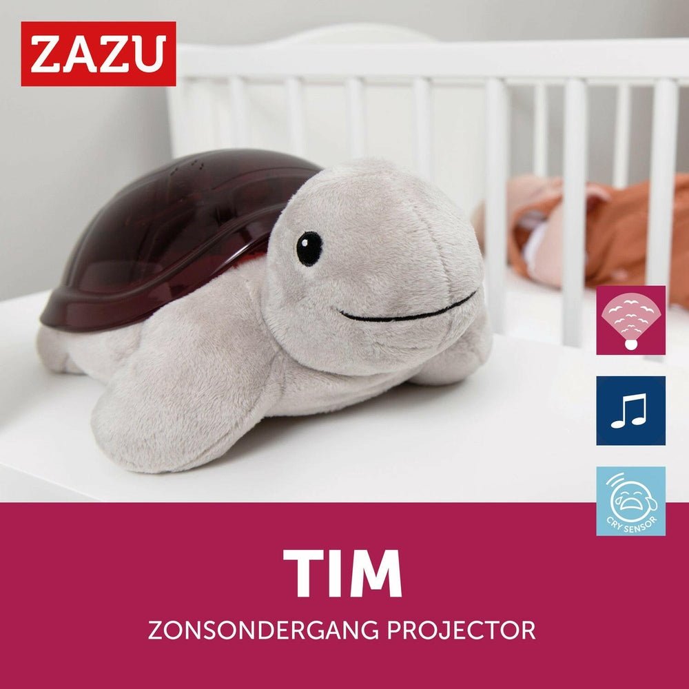 Grijze pluche schildpad projector naast wieg met slaapfuncties