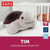 Grijze pluche schildpad projector naast wieg met slaapfuncties