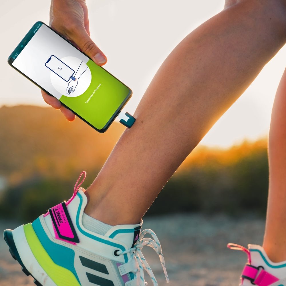 Heat-it device in gebruik op been tijdens sporten met app 'Treatment in Progress'