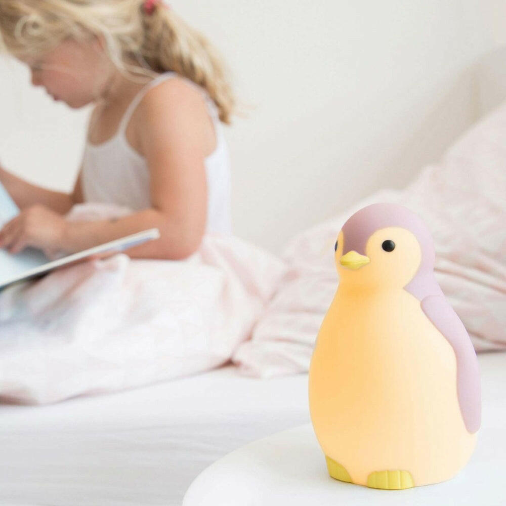 Geel-witte Zazu pinguïn lampje bij lezend meisje op bed