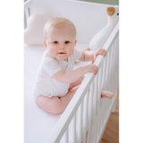 Wit AirgoSafe hoeslaken met mesh-structuur onder babymeisje in wieg