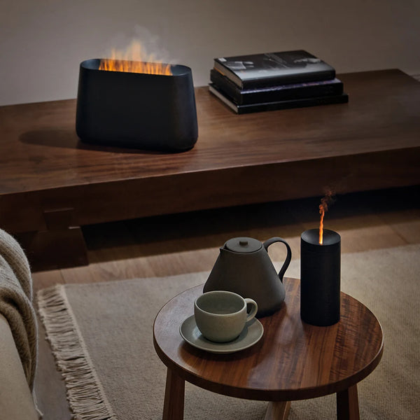 Twee zwarte Stadler Form diffusers met oranje gloed effect interieur