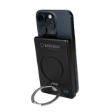Zwarte Waka Waka powerbank met LED-display en kickstand bevestigd aan smartphone
