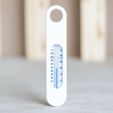 Witte Bébé-jou badthermometer met °C en °F schaal en ophanggaatje op grijze ondergrond