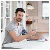 Man meet bloeddruk thuis met Medisana app verbinding via smartphone