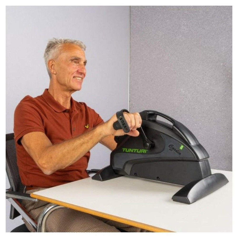 Tunturi Cardio Fit M35 Minibike gebruikt aan bureau met handgrepen