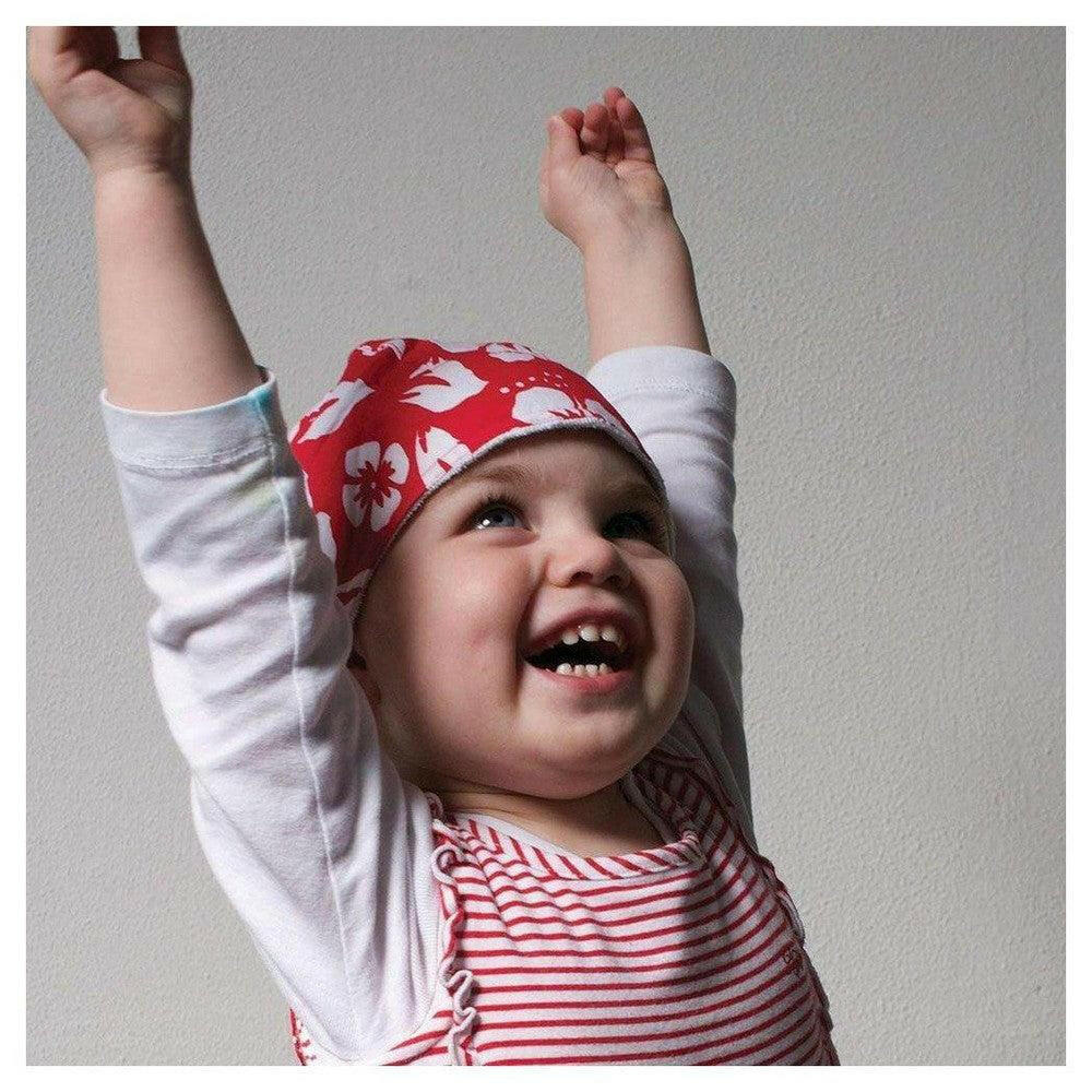 Rode BabyWrapz bandana met bloemenpatroon op baby hoofd