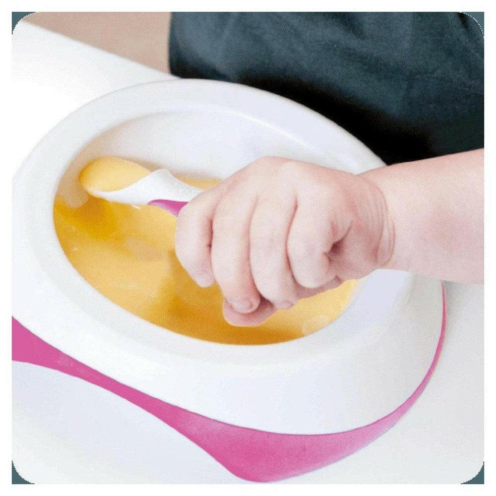 Baby leert zelf eten met roze Difrax peuterkom en antislip lepel