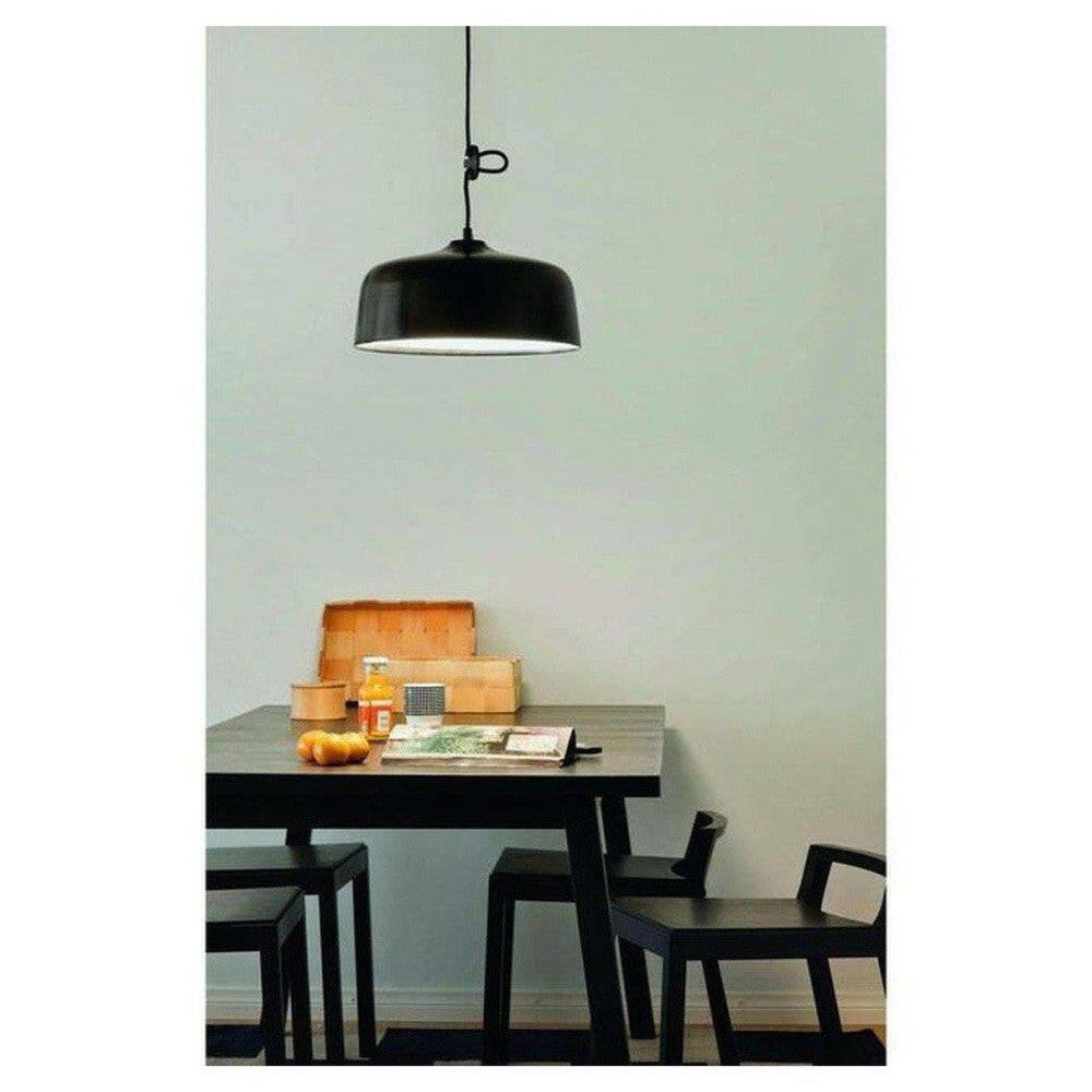 Zwarte Innolux Candeo lamp op donkere houten tafel